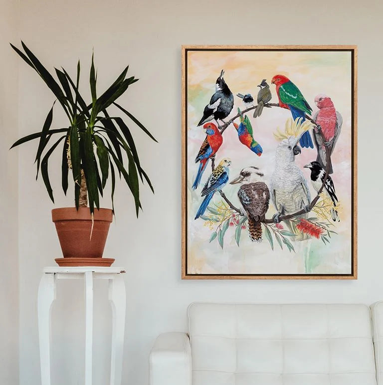 Living room with a white sofa, potted plant on a small table, and a colorful bird painting on the wall.